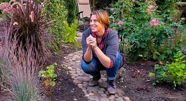 Amy crouching on a stone garden path