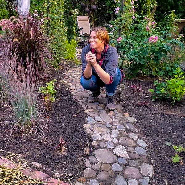Amy crouching on rock walkway in garden