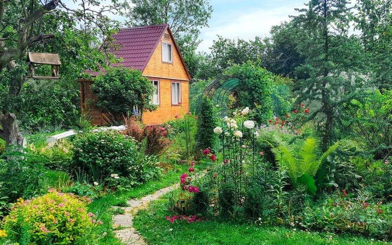 beautiful cottage garden in front of an older house with meandering path.