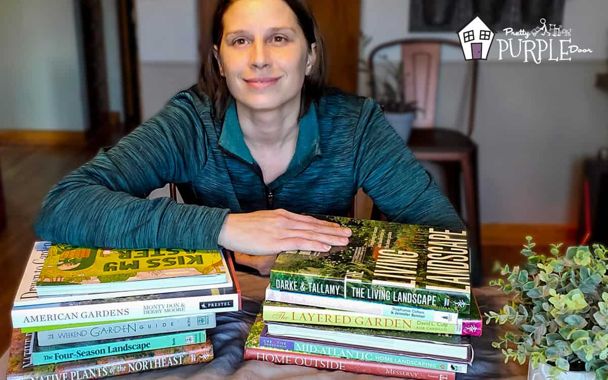 Amy learning on stacks of gardening books