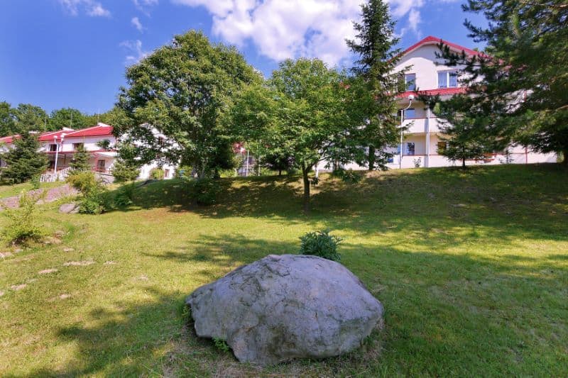 a sloped property with stones and grass